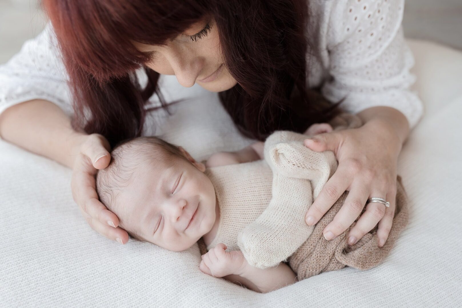 nouveau-né souriant dans les bras de sa mère