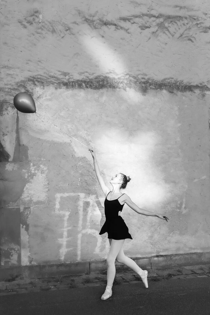 danseuse classique courant derrière un ballon