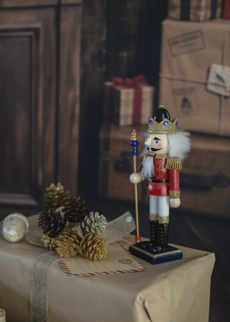 Casse-noisette en bois, pommes de pin dorées et enveloppe par avion sur un paquet cadeau kraft